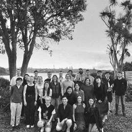 Black and white photo of team in front of Auckland skyline
